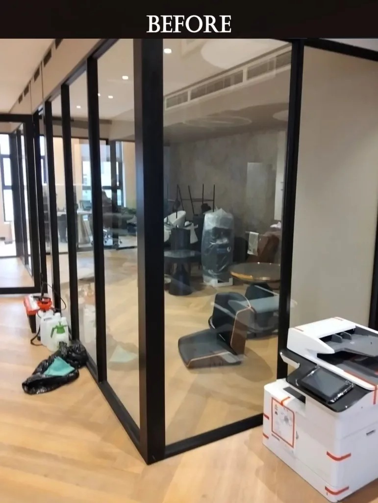Office space before renovation showing clutter and transparent glass partition.